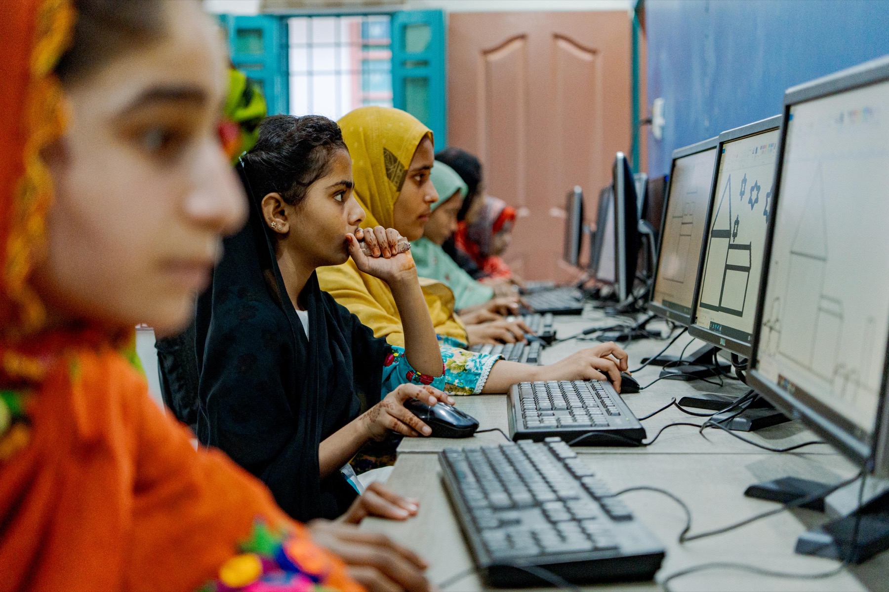 Girls using computers in a WALI digital literacy session in Lasbela